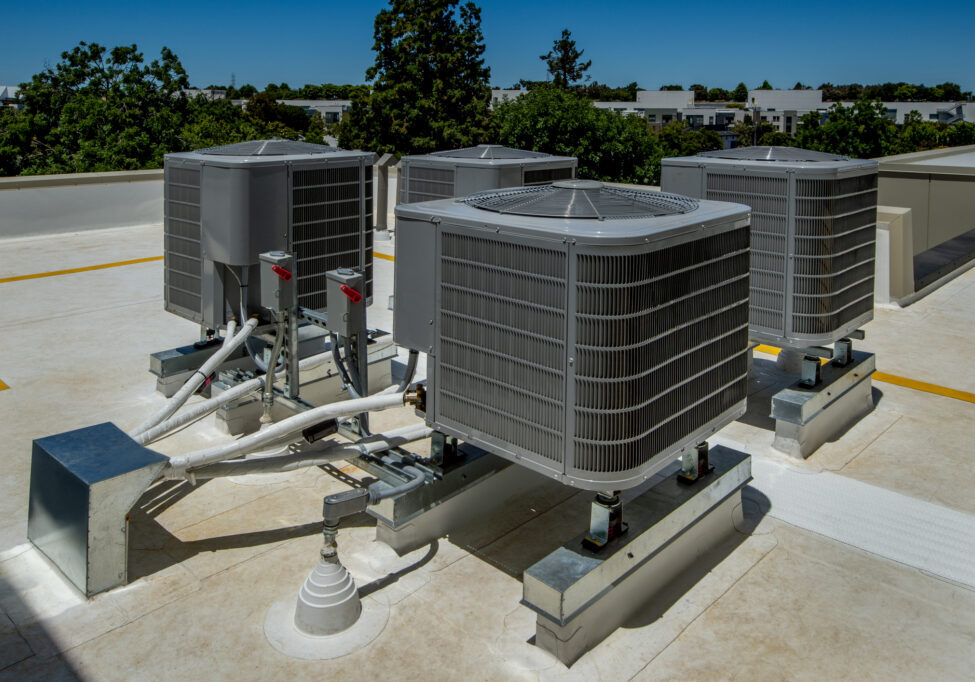 Set of four air conditioning units on a membrane roof.